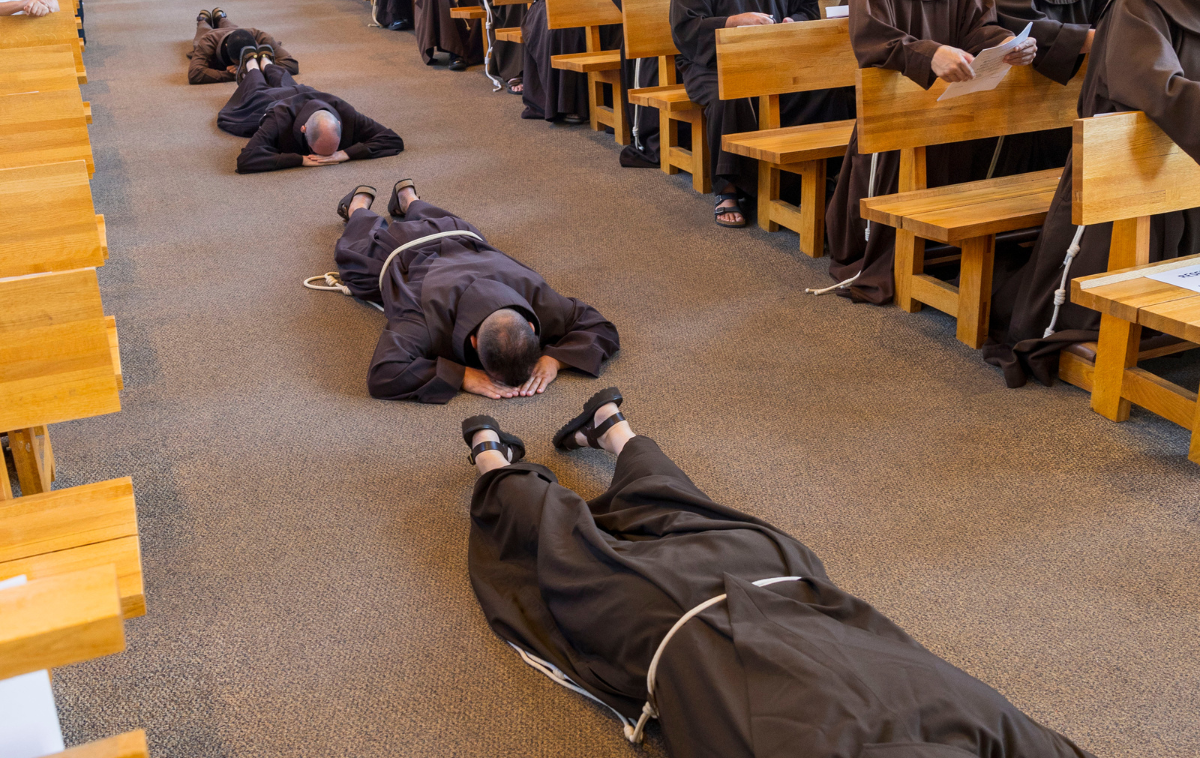 The four friars lie face down in the aisle of the church.