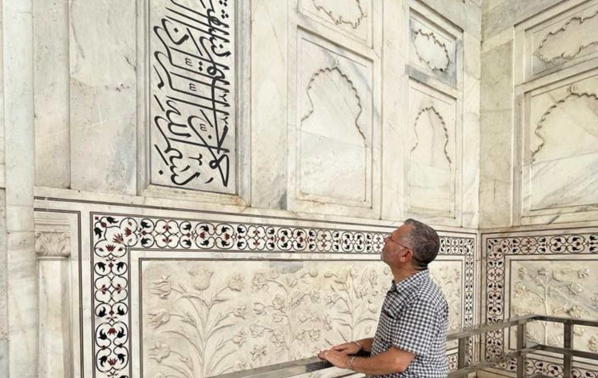 A man studies the intricate, beautiful Qur’anic inscriptions on the inside of the Taj Mahal.