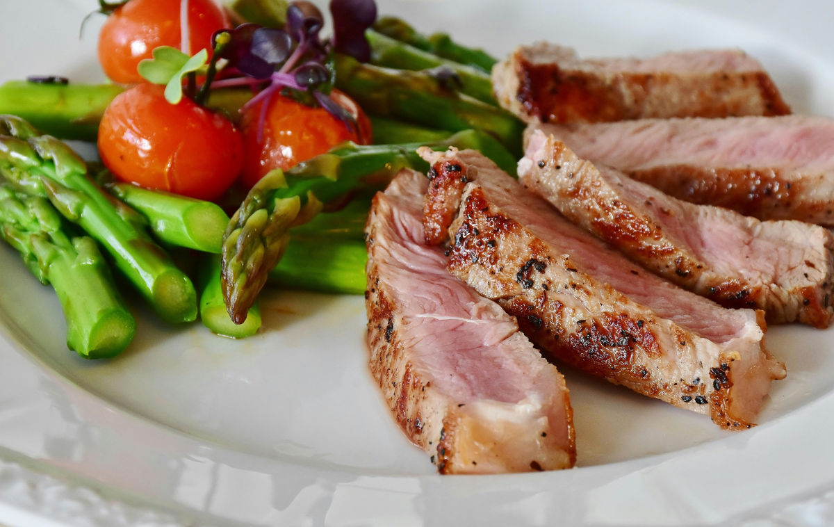 A plate of roasted pork and vegetables.