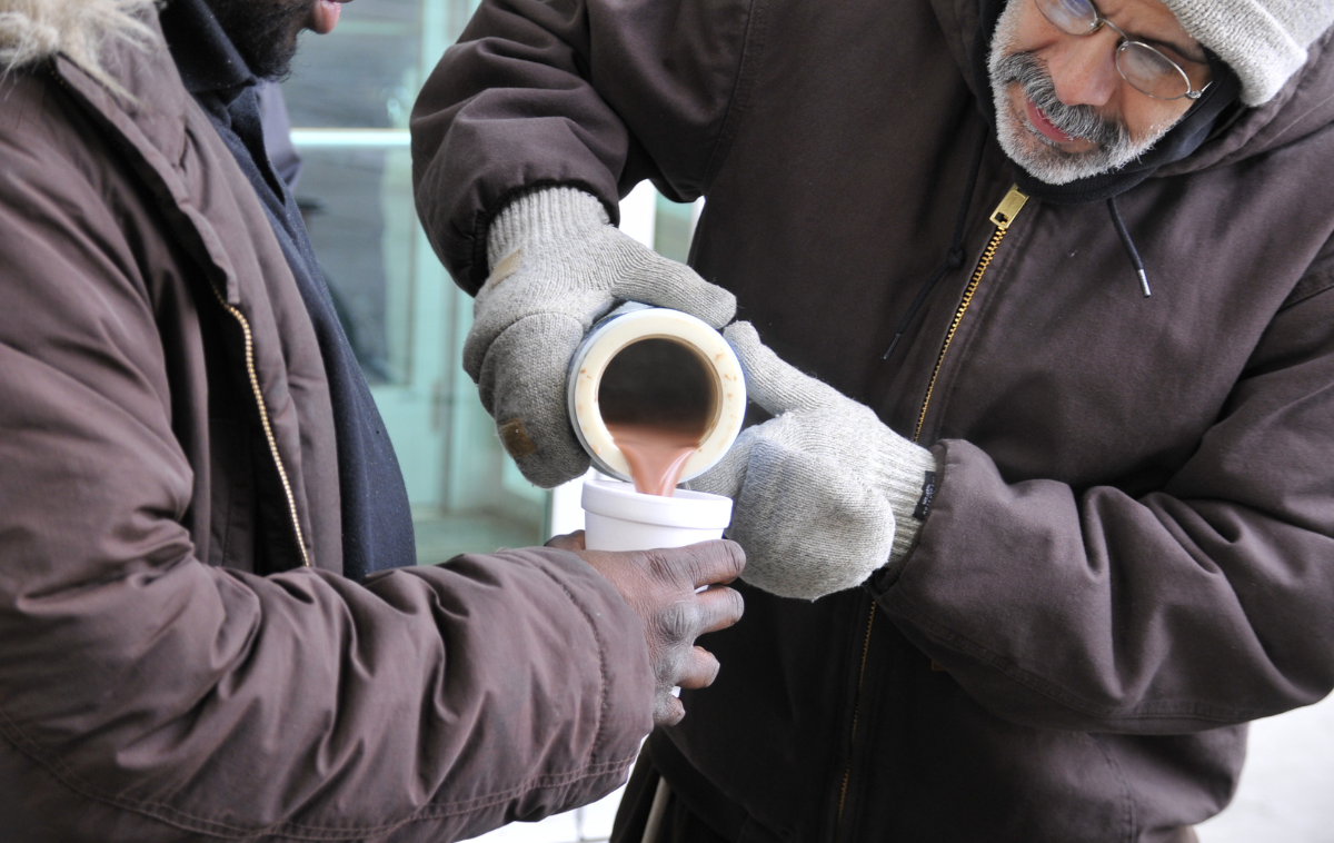 A friar pours coffee for someone.