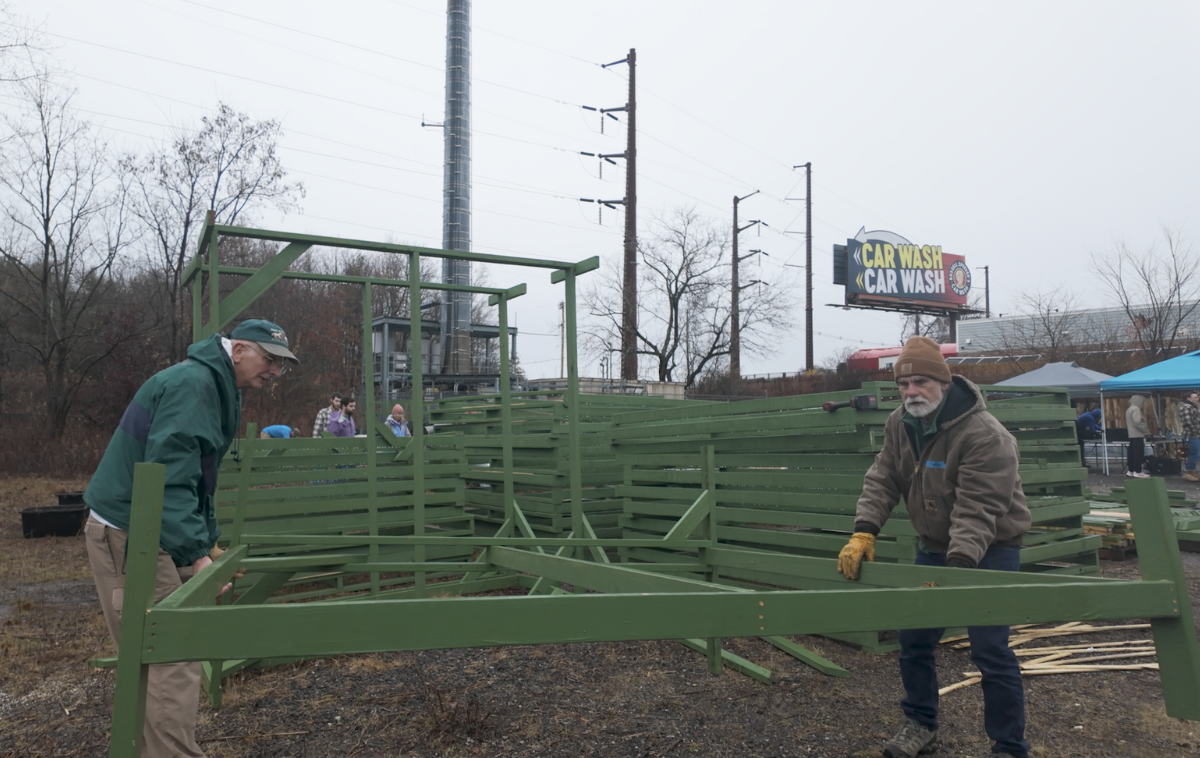 Two men work together to build raised garden beds.