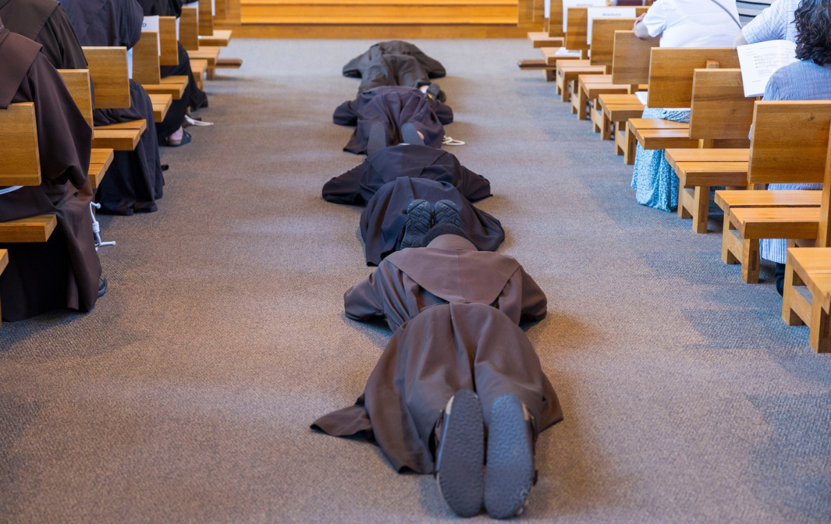 During the Litany of the Saints at a solemn profession, friars lay prostrate 
as part of the ceremony. Their vow of poverty does not mean a rejection of the world but rather demonstrates a commitment to solidarity with individuals whose lives are characterized by vulnerability or need. (Province file photo)