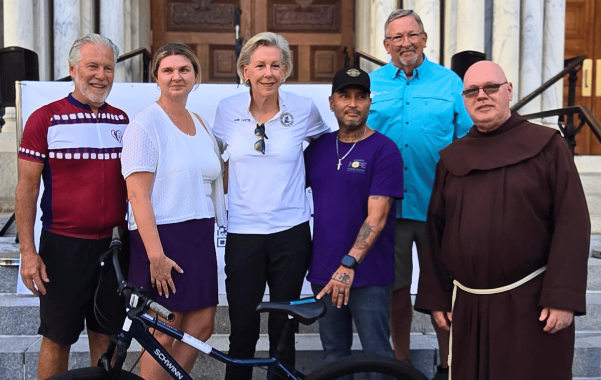 From left, Tim Eves, Catholic Charities of the Diocese of St. Petersburg executive director Maggie Rogers, Tampa mayor Jane Castor, Tom Henry and Br. Michael Jones, OFM. "It's easy to overlook how vital basic transportation is until you see someone's life open up because they now have a reliable way to get to work, school, or medical appointments," Br. Mike said. "It has shown me that small, deliberate efforts, multiplied over time, create profound community transformation. (Photo courtesy of Sacred Heart Parish)