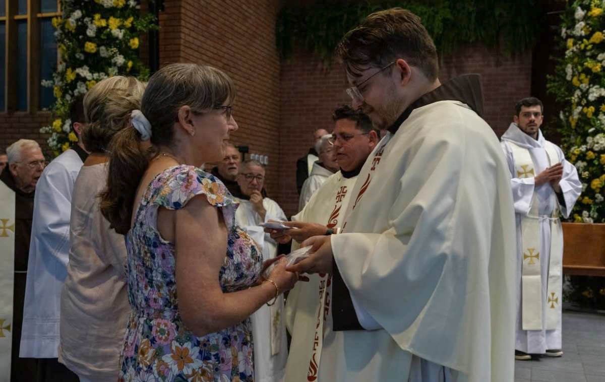 Br. Joshua presents his maniturgium - the white linen cloth used to wipe the chrism from his hands - to his mother. (Photo courtesy of Br. Octavio Duran, OFM)