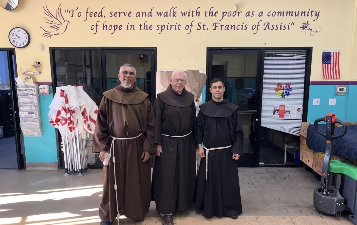 Brothers Raul Diaz, OFM, Ignatius Harding, OFM, and Victor Vega, OFM, stand 
before St. Francis Center&rsquo;s mission statement, which has guided the 
ministry for more than 54 years. &ldquo;The hope,&rdquo; Br. Victor says, &ldquo;is that 
people experience care and love&hellip; that they feel safe and truly welcome.&rdquo; (Photo courtesy of St. Francis Center)