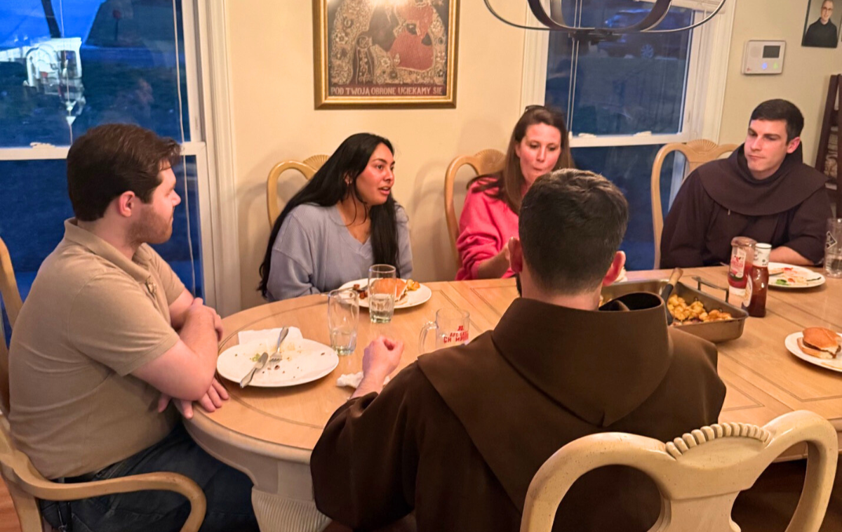 Brothers&nbsp;Casey&nbsp;Cole, OFM (far right) and Jason&nbsp;Damon, OFM,&nbsp;enjoy a meal with young adults at their residence in downtown Charlotte. (Photos by Chris Rivera)